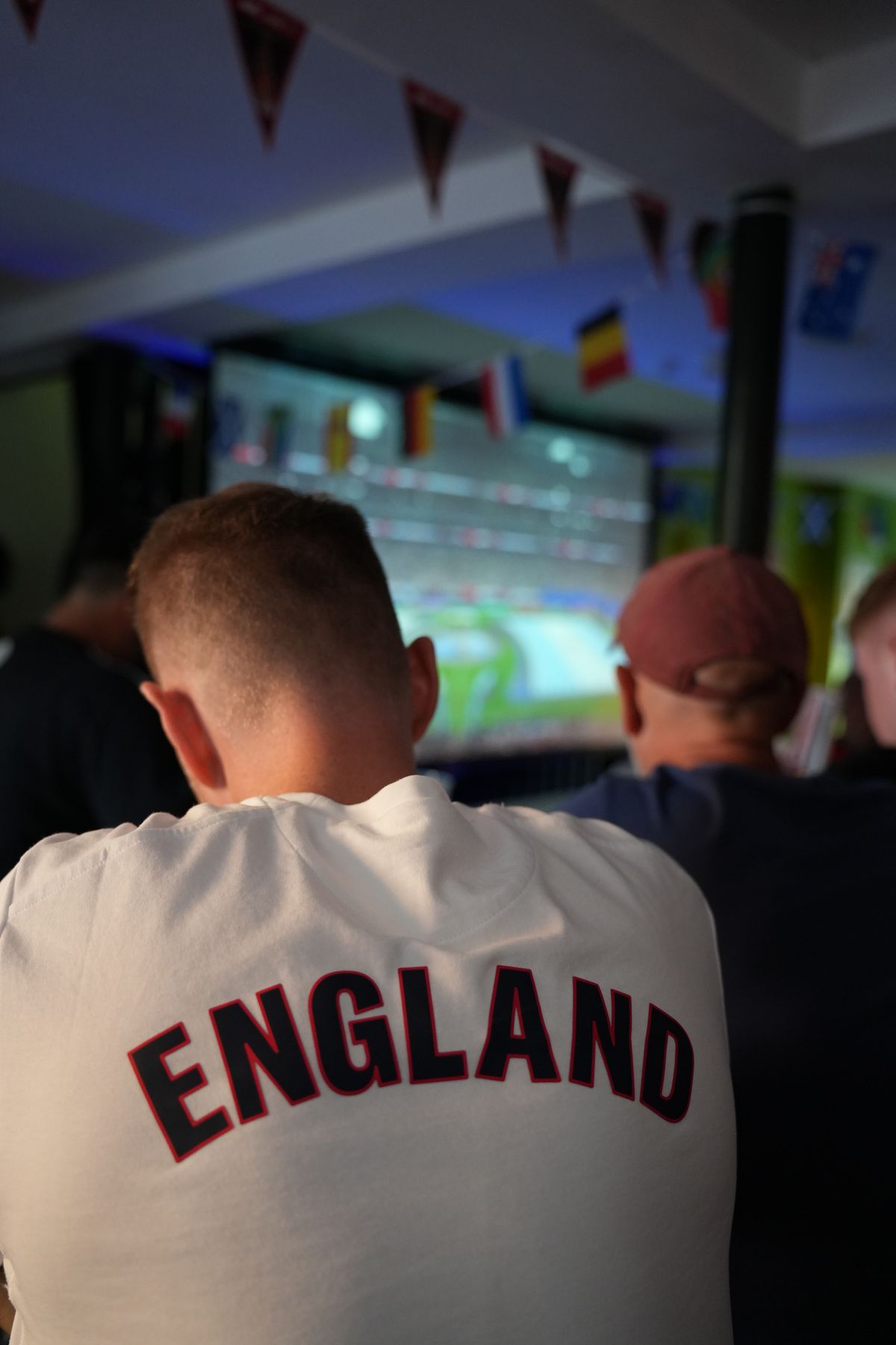 fan in an England shirt watching the screen
