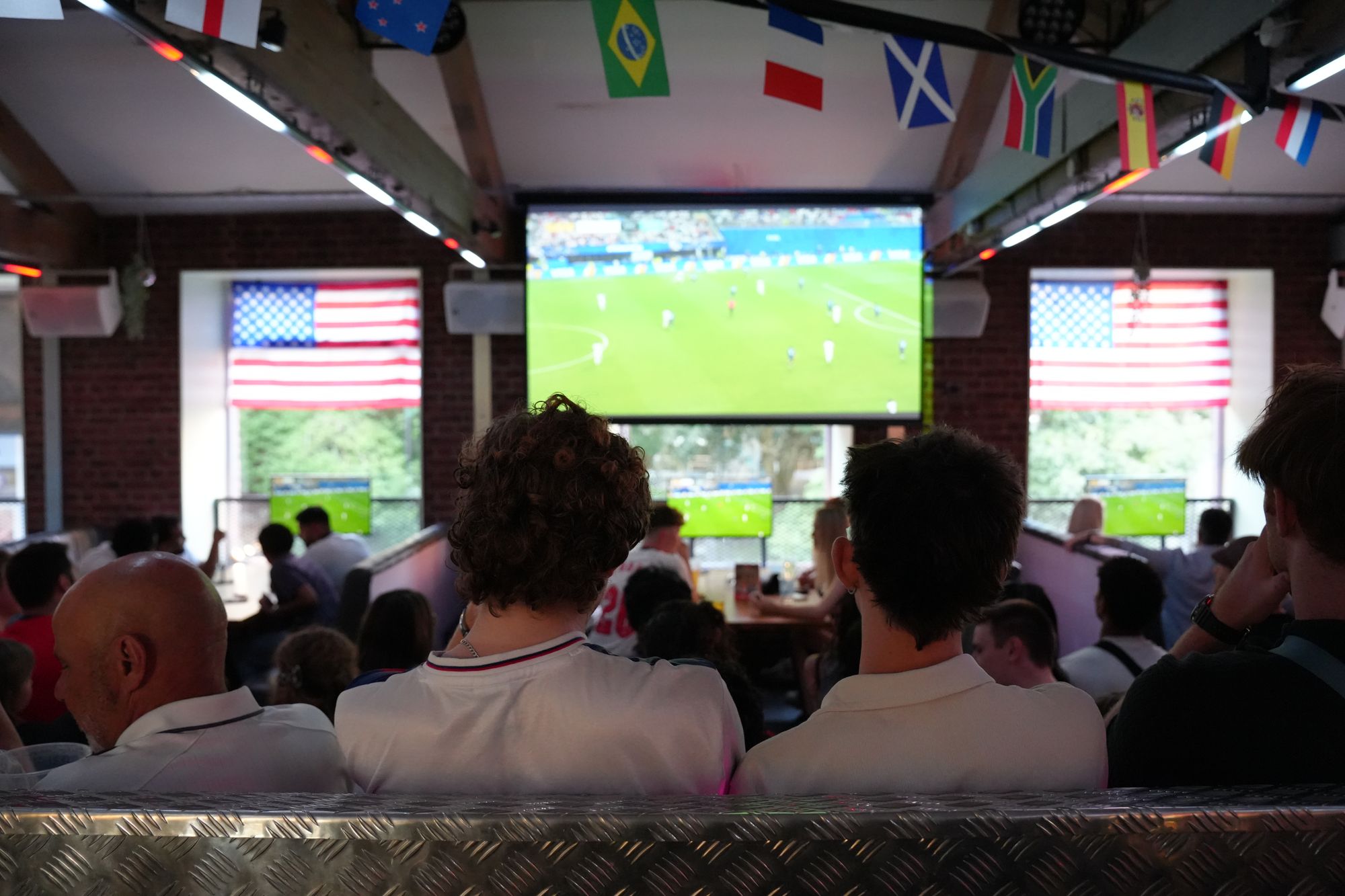 fans watching football on the big screen in the bar